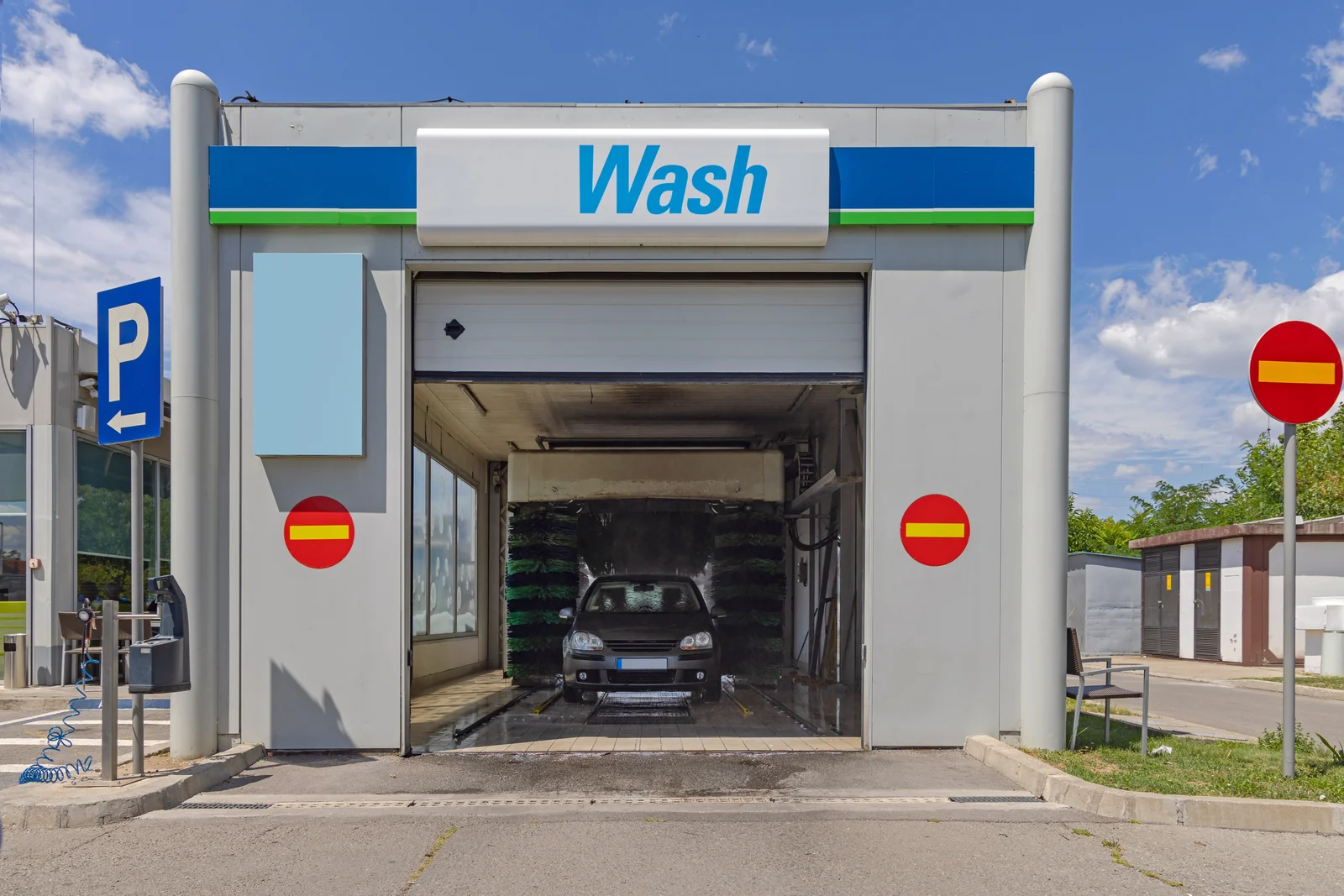 A vehicle passing between rotating cloth brushes inside an in-bay automatic wash
