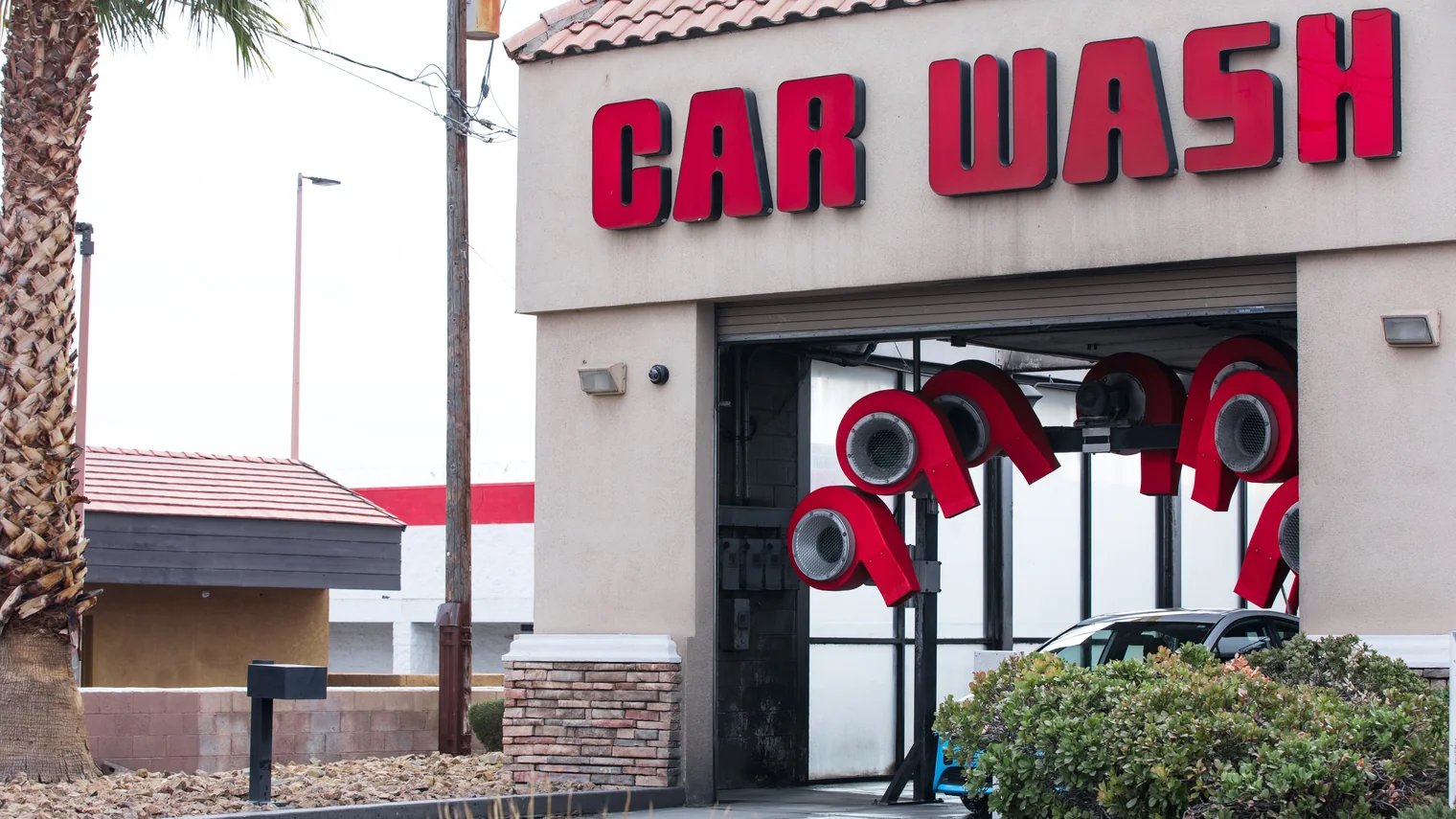Dryer housings mounted above the exit of an automatic car wash bay