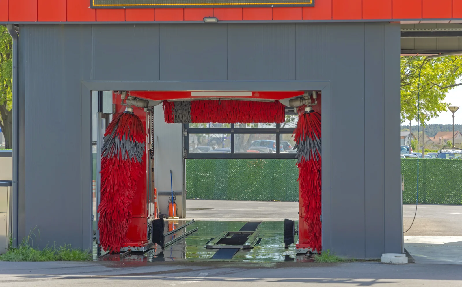 An empty in-bay automatic wash with the brush gantry parked to one side