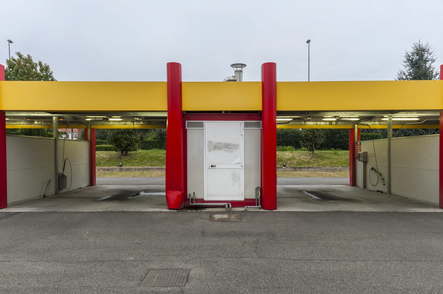 The front elevation of a self-service car wash with open bays either side